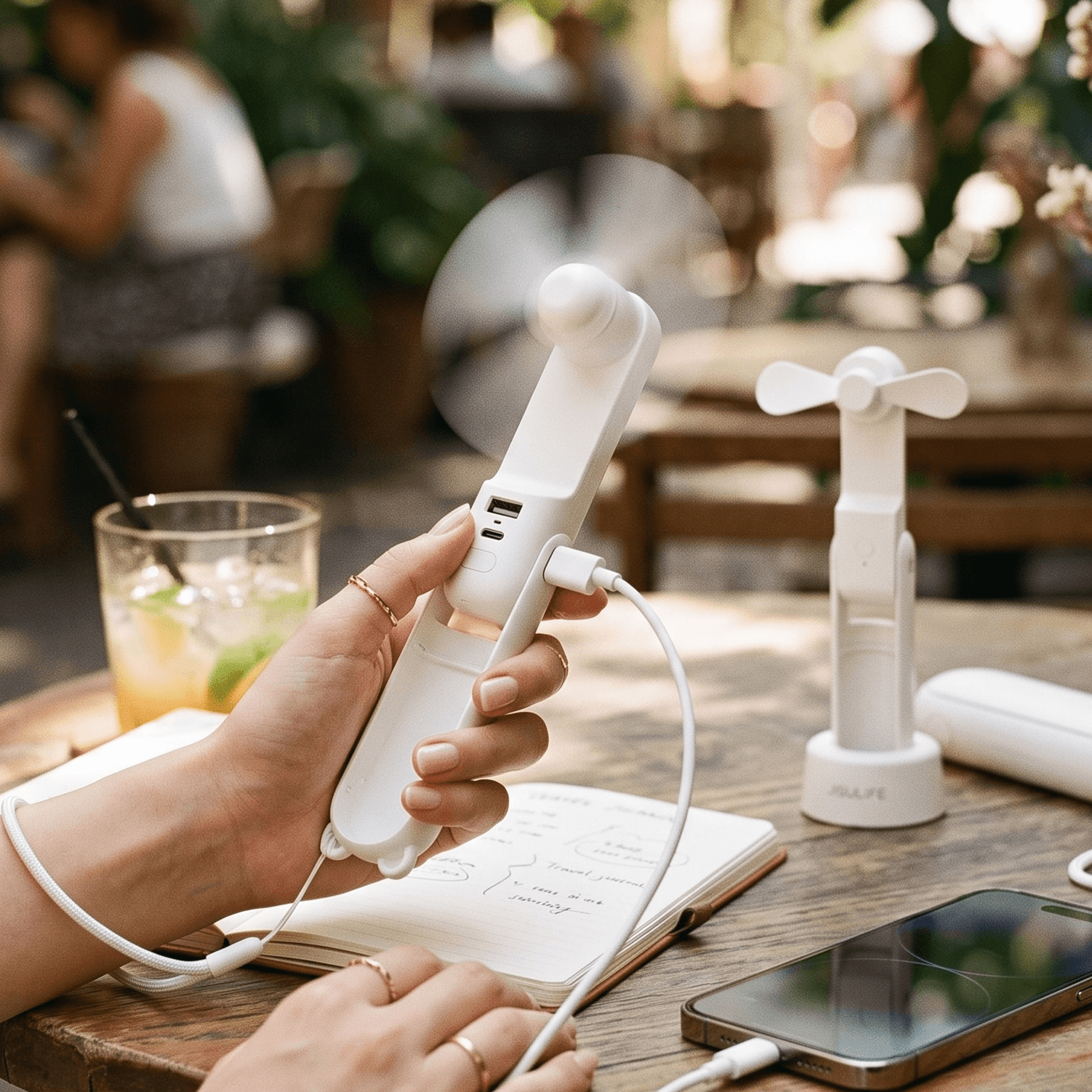 Breeze One w użyciu na letniej kawiarni — chłodzi i jednocześnie ładuje telefon